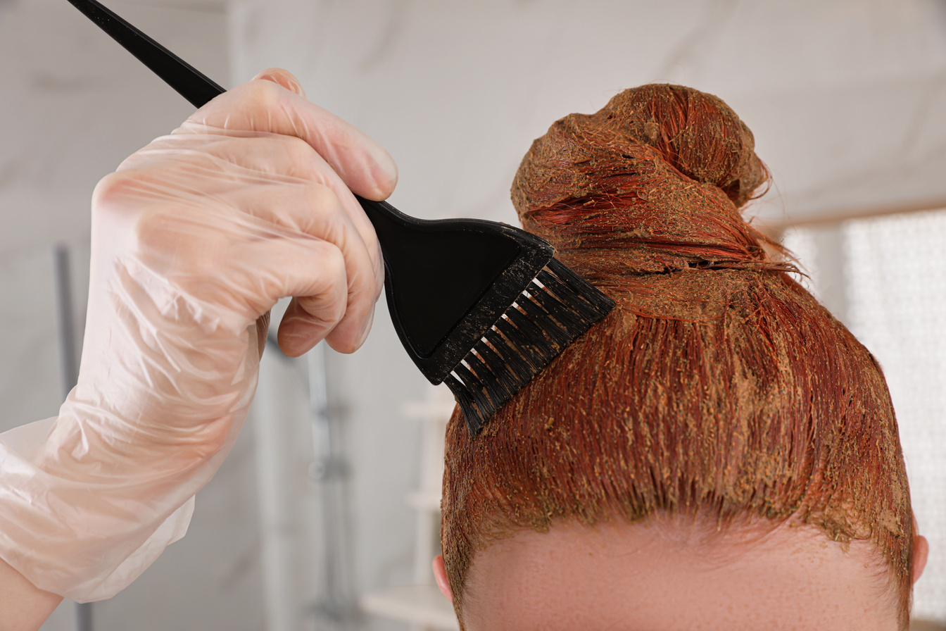 Young Woman Dyeing Her Hair with Henna Indoors, Closeup